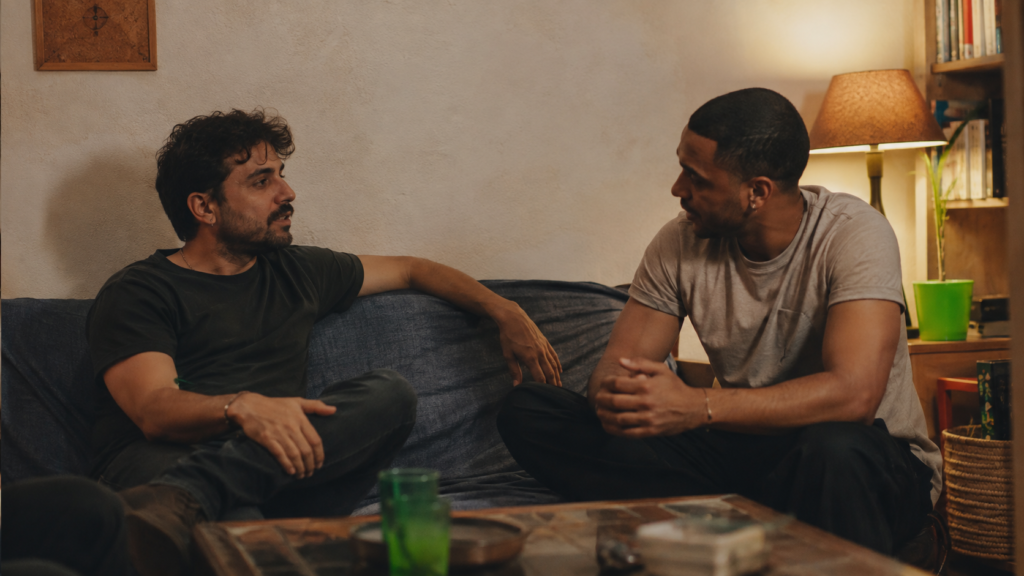 Dos hombres adultos conversando con cercanía y espacio personal en un ambiente íntimo